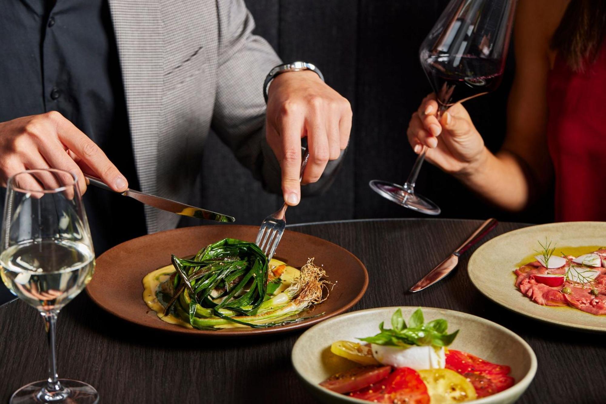 Melbourne Marriott Hotel Docklands Eksteriør bilde A man using a knife and fork to cut into a meal